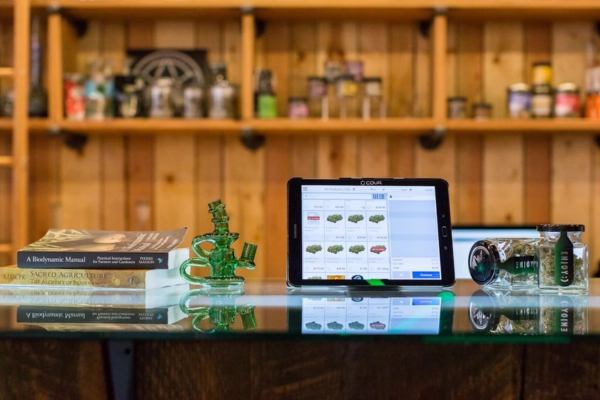 Cannabis dispensary counter with tablet, books, and glass pieces