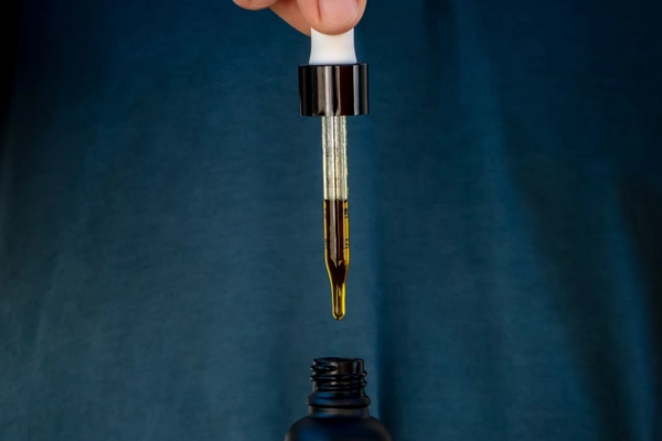 THC tincture dropper above a dark bottle