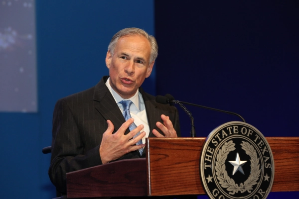 Governor Greg Abbott speaking at a podium in Texas