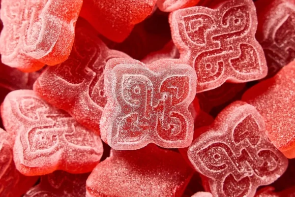 Close-up of red cannabis gummies with sugar-coated texture